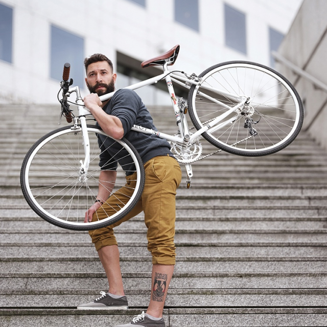 Vélo de route rétro Peugeot Legend Road sur épaule d'un homme dans les escaliers