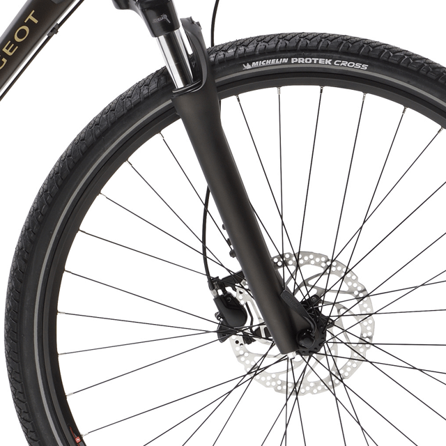 Visuel rapproché sur le pneu avant Michelin Protek Cross d'un vélo Peugeot modèle eT01 Sport